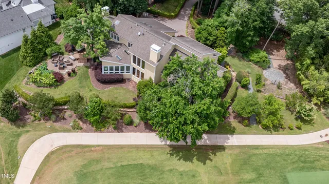 an aerial view of a residential houses with yard