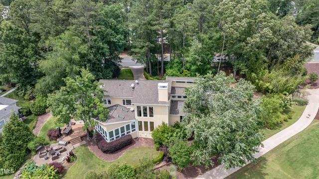 an aerial view of residential house with outdoor space and trees all around