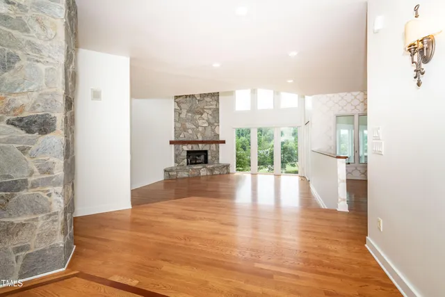 a view of empty room with wooden floor and fireplace