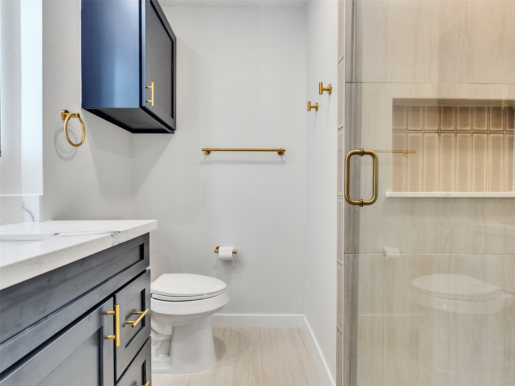 10315 Winding Trail Road La Porte, TX 77571 - Photo 16 of 24 Experience modern elegance in this primary bath, featuring sleek cabinetry, luxurious fixtures, and a spacious glass shower, all enhanced by tasteful gold accents.
