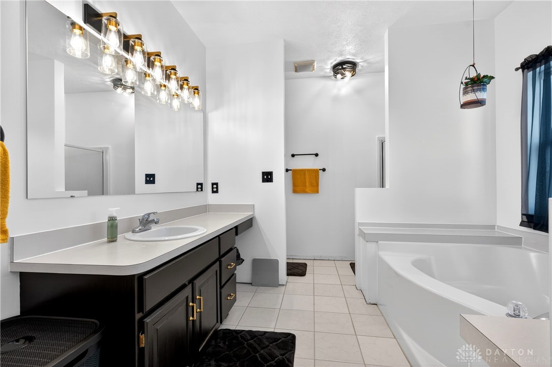6560 Snyder Road Fletcher, OH 45326 - Photo 31 of 71 This spacious bathroom offers a relaxing soaking tub and ample vanity space.