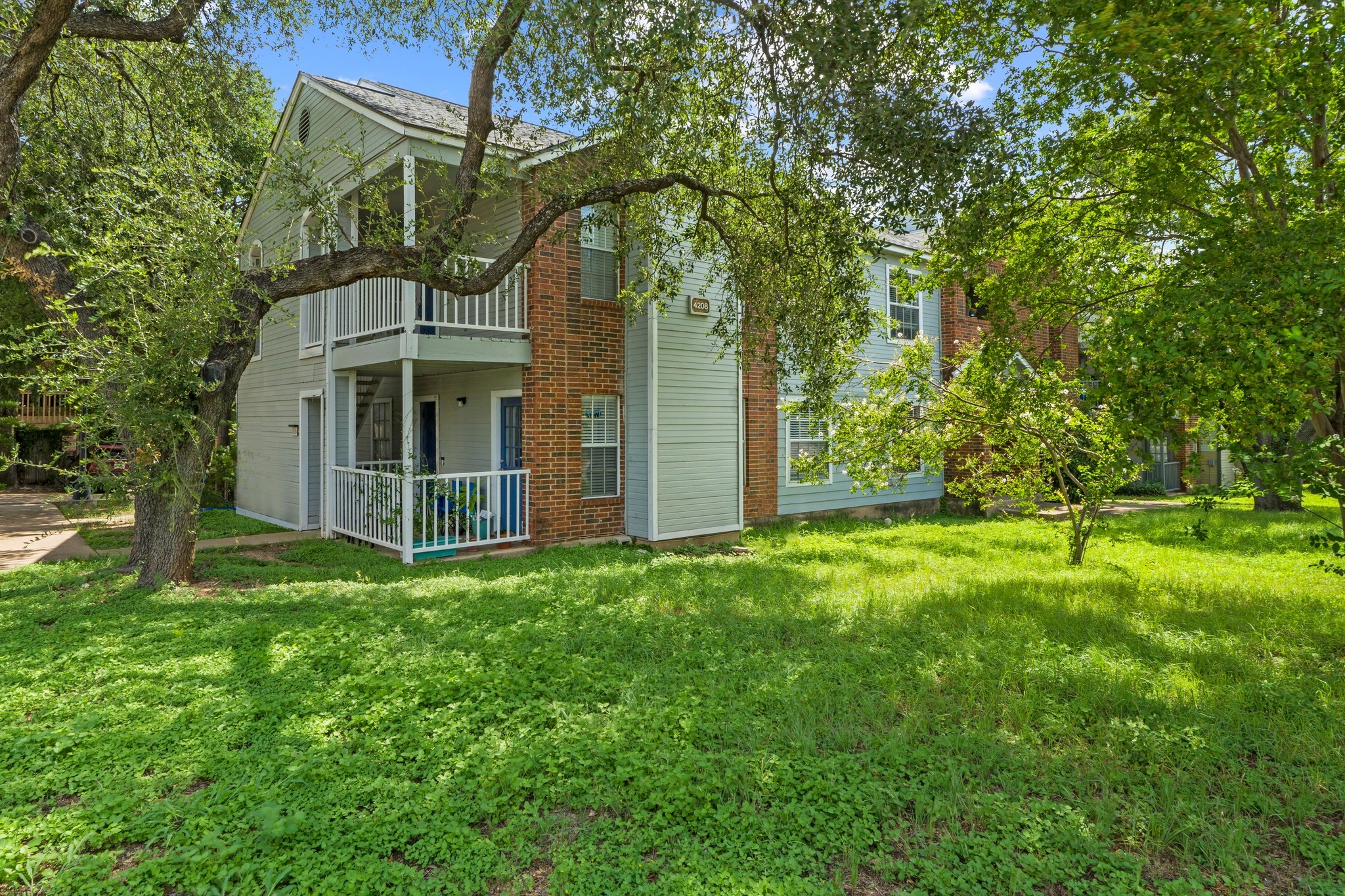 Rear view of house featuring a balcony and a lawn