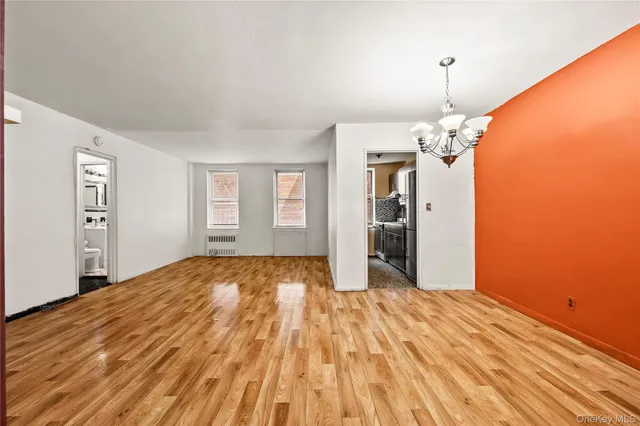 a view of empty room with wooden floor and window