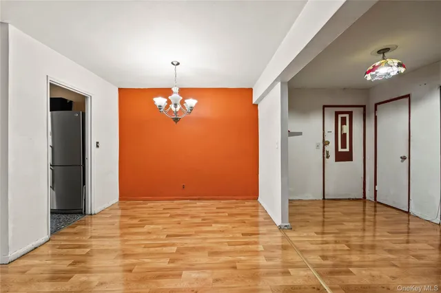 a view of an empty room with chandelier fan