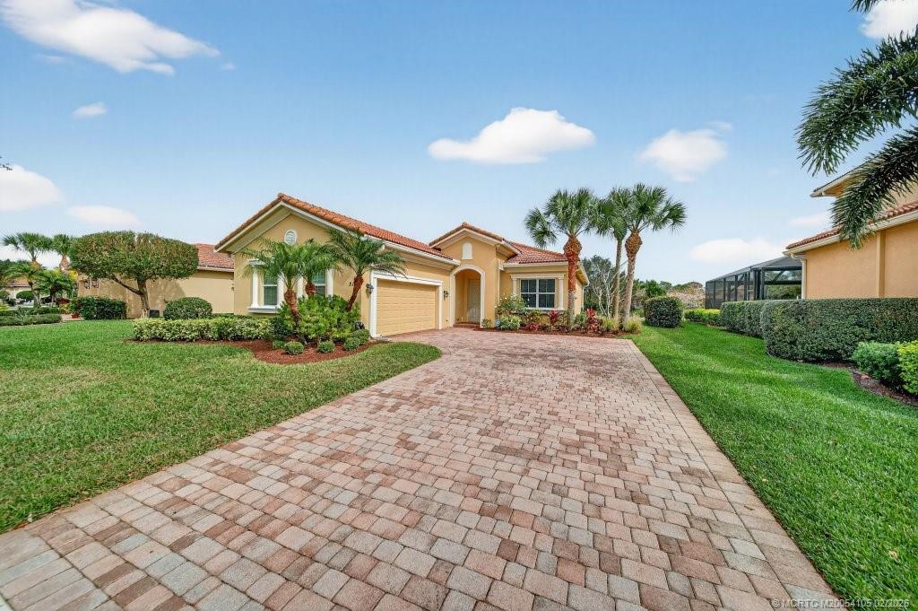 8121 Southwest Marin Drive Stuart, FL 34997 - Photo 1 of 31 a front view of a house with a yard and potted plants
