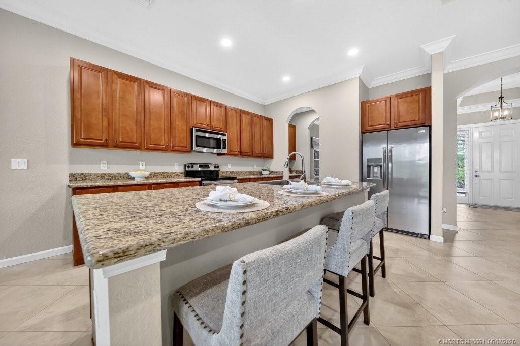 8121 Southwest Marin Drive Stuart, FL 34997 - Photo 13 of 31 a kitchen with stainless steel appliances granite countertop a sink stove refrigerator and cabinets