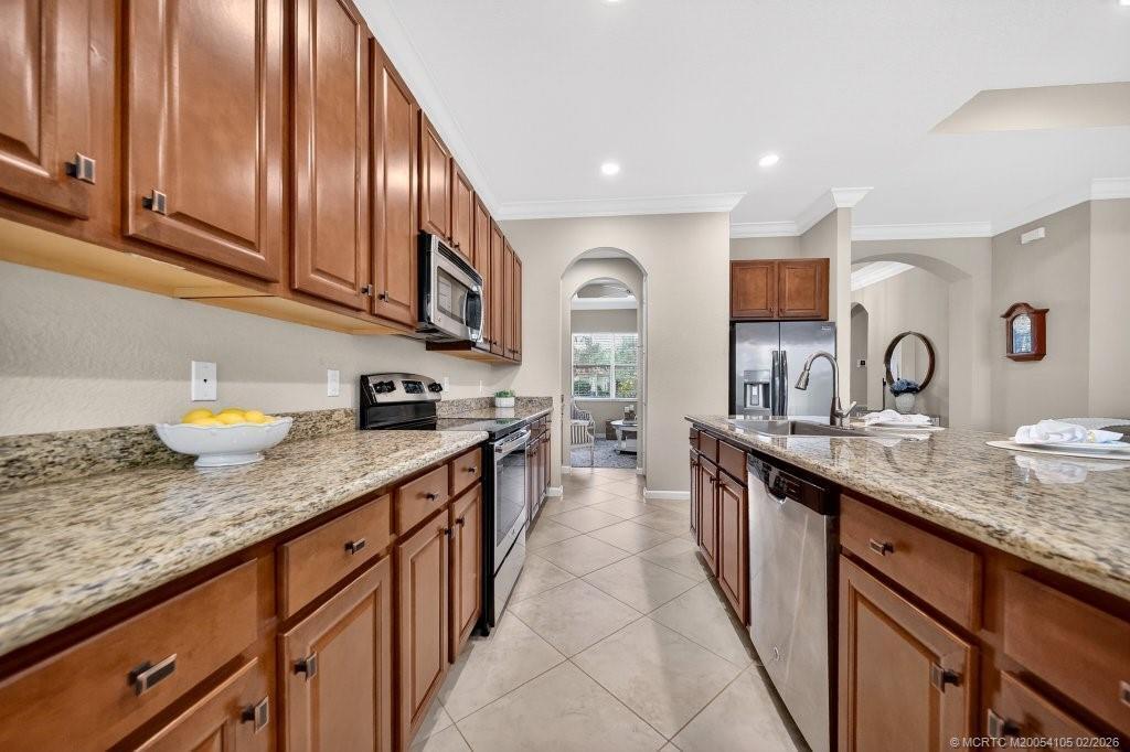 8121 Southwest Marin Drive Stuart, FL 34997 - Photo 14 of 31 a kitchen with stainless steel appliances granite countertop a sink stove and cabinets