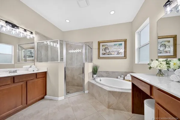 a spacious bathroom with a double vanity sink mirror and bathtub