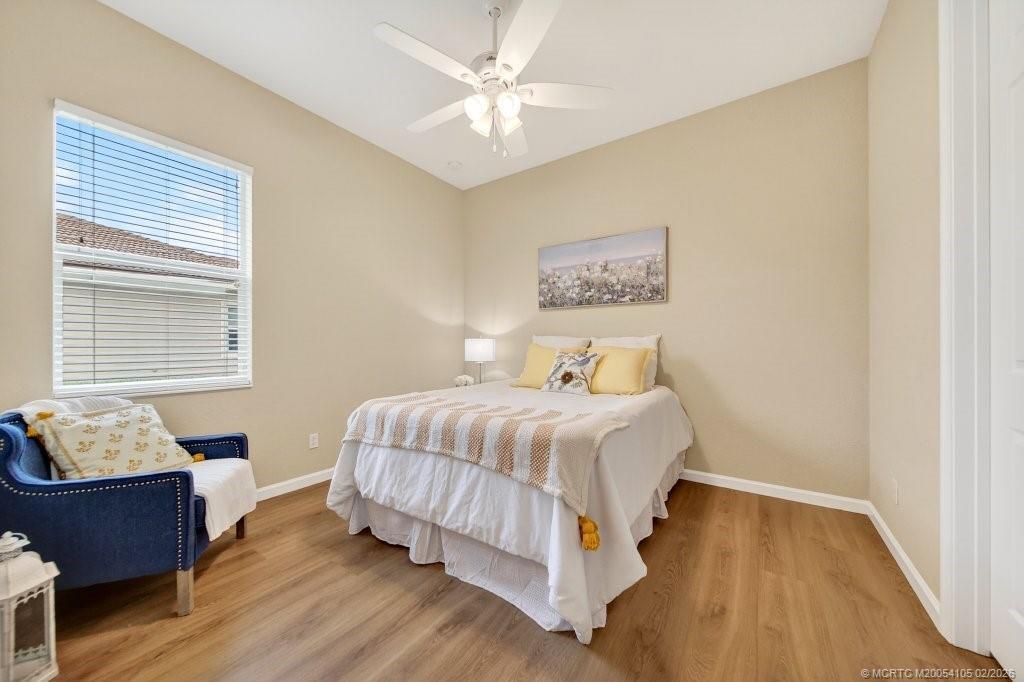 8121 Southwest Marin Drive Stuart, FL 34997 - Photo 20 of 31 a bedroom with a bed and wooden floor