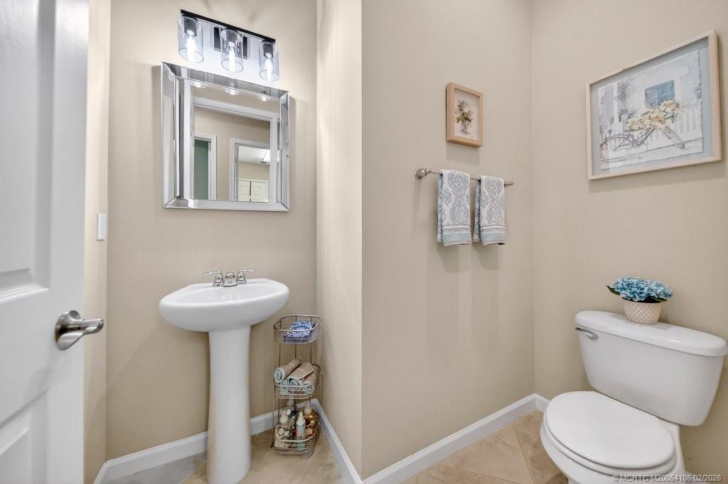 8121 Southwest Marin Drive Stuart, FL 34997 - Photo 23 of 31 a bathroom with a toilet sink and mirror
