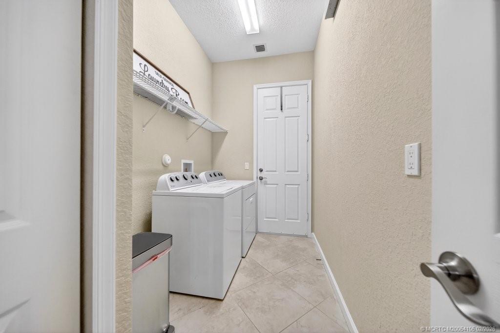 8121 Southwest Marin Drive Stuart, FL 34997 - Photo 24 of 31 a utility room with cabinets washer and dryer