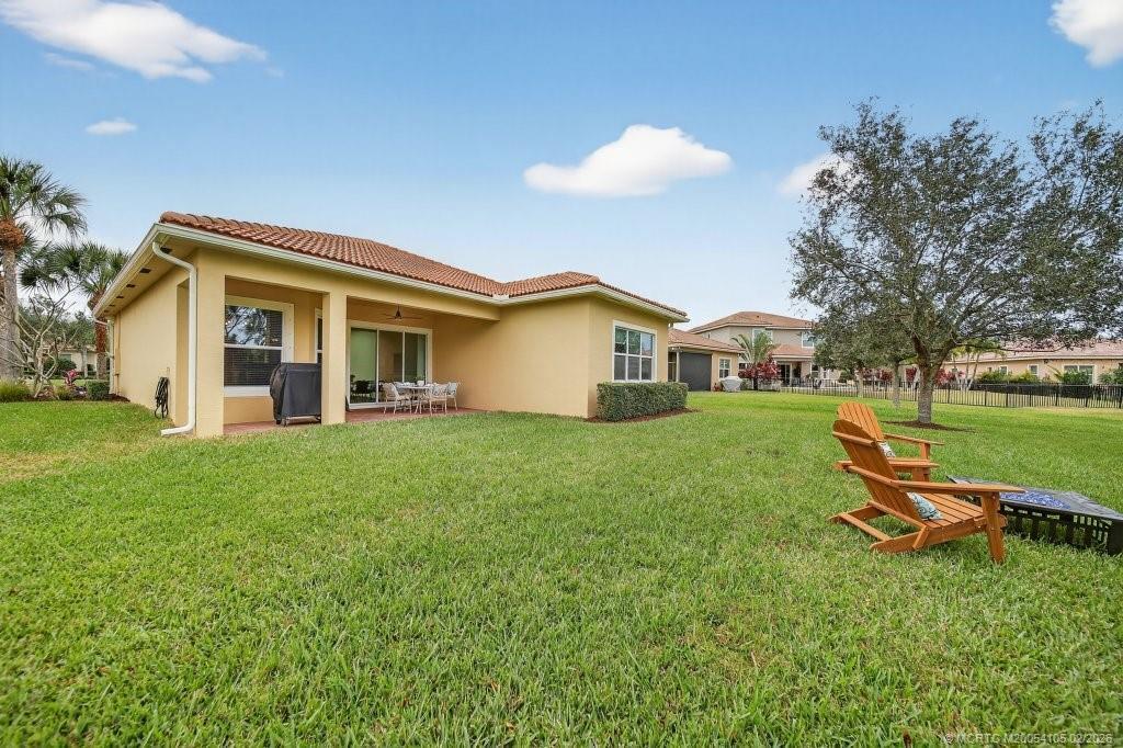 8121 Southwest Marin Drive Stuart, FL 34997 - Photo 26 of 31 a backyard of a house with table and chairs