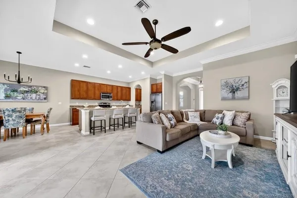 a living room with furniture kitchen view and a large window