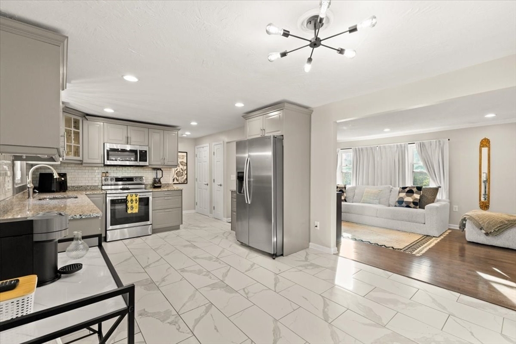 3 Federal Street, Unit 3 Blackstone, MA 01504 - Photo 9 of 27 a kitchen with stainless steel appliances kitchen island granite countertop a refrigerator a stove a sink a oven with white cabinets and chairs