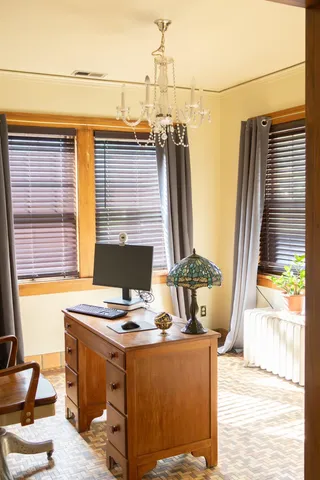 a view of a workspace with furniture and a window