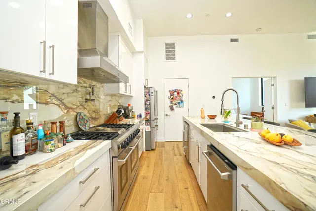 a kitchen with stainless steel appliances a sink stove and cabinets