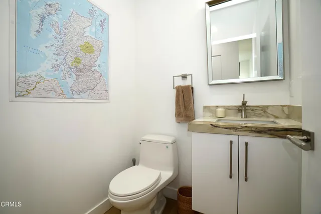 a bathroom with a granite countertop toilet sink and mirror