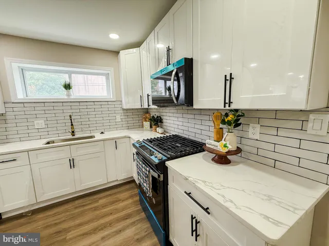 a kitchen with granite countertop a sink stainless steel appliances and cabinets