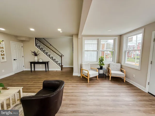 a living room with furniture floor to ceiling window and wooden floor
