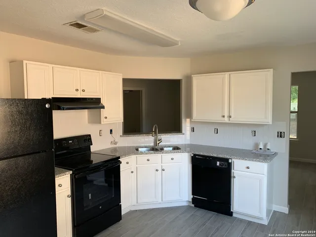 a kitchen with a sink dishwasher and a stove top oven