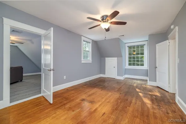 a view of a livingroom with a chandelier fan and windows