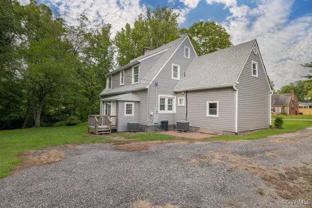 a view of a house with backyard and trees