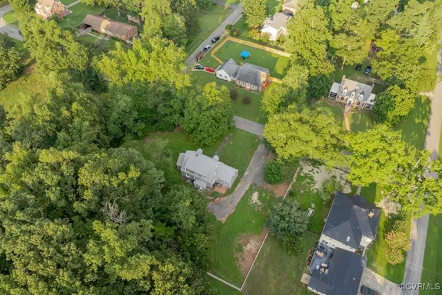 an aerial view of residential house with outdoor space and trees all around