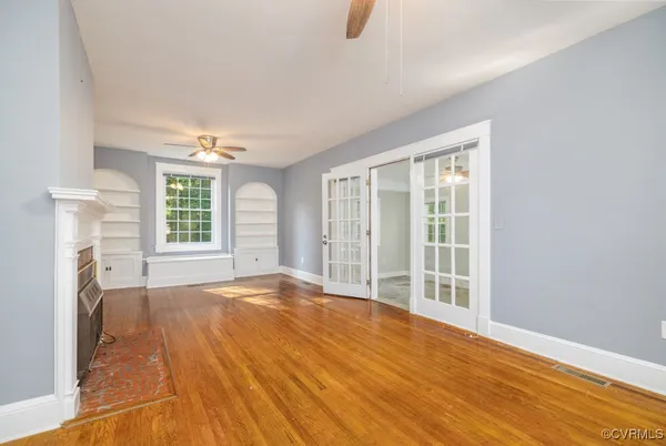 a view of an empty room with a fireplace and a window