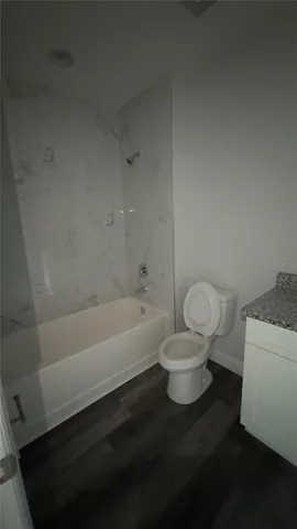 a white toilet sitting next to a bathtub