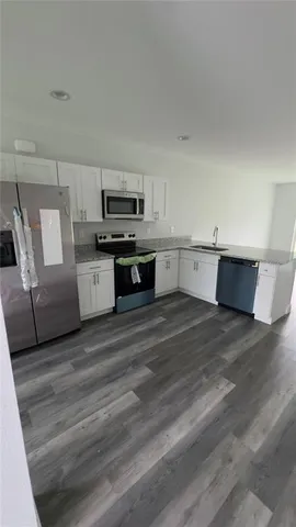 a large white kitchen with cabinets