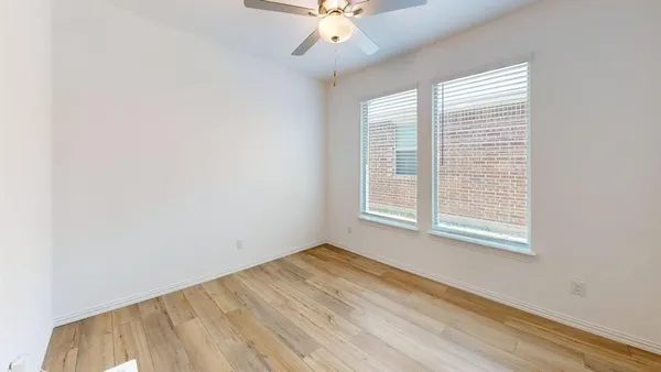 an empty room with a window and a fan