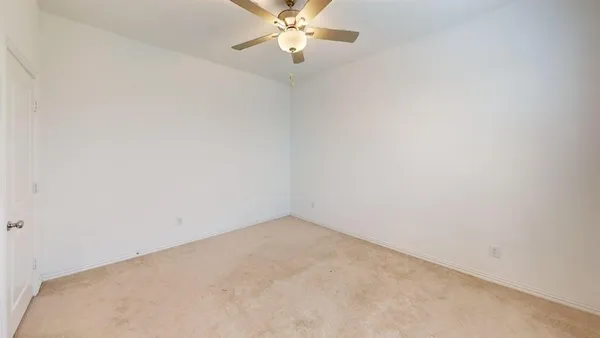 an empty room with a window and a ceiling fan