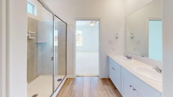 a bathroom with a tub sink shower and two mirror