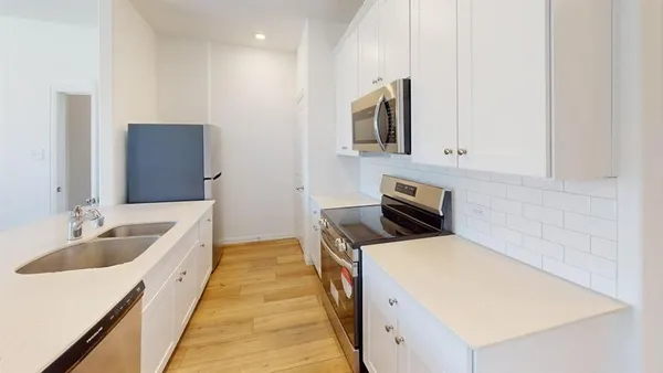 a kitchen with granite countertop a sink and a stove top oven