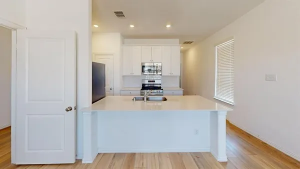 a room with kitchen island a sink a stove and a window