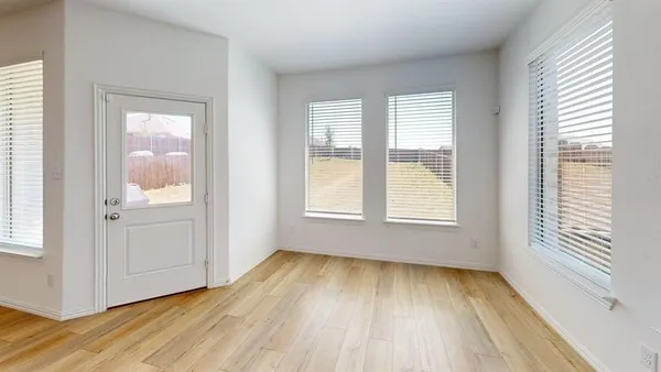 a view of wooden floor in an empty room with a window