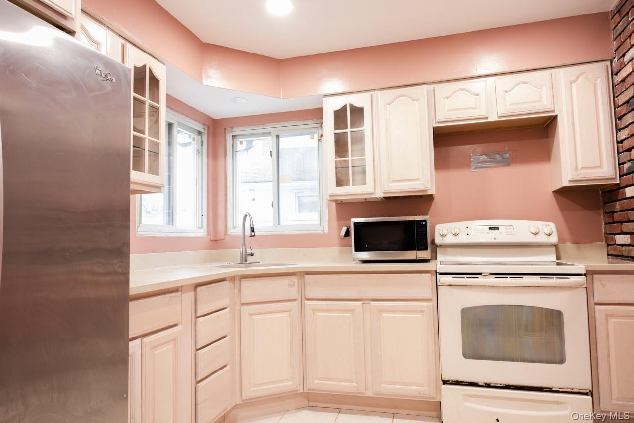 1322 Barry Drive South Valley Stream, NY 11580 - Photo 10 of 12 a kitchen with granite countertop a stove a sink and a microwave