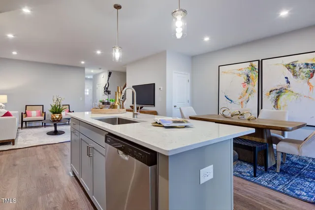 a kitchen that has a lot of cabinets a sink and wooden floor