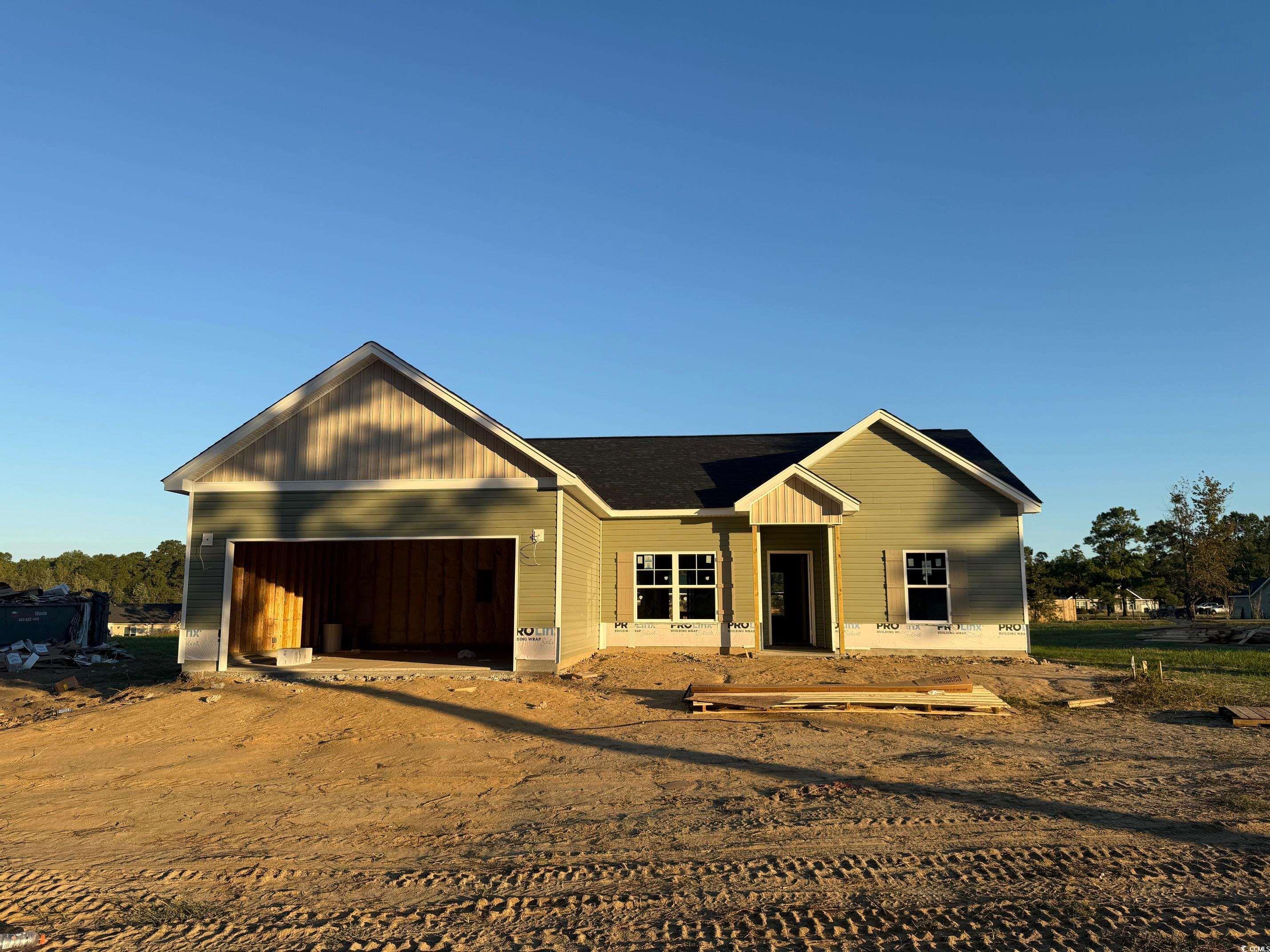 View of front of home featuring dirt driveway and a garage