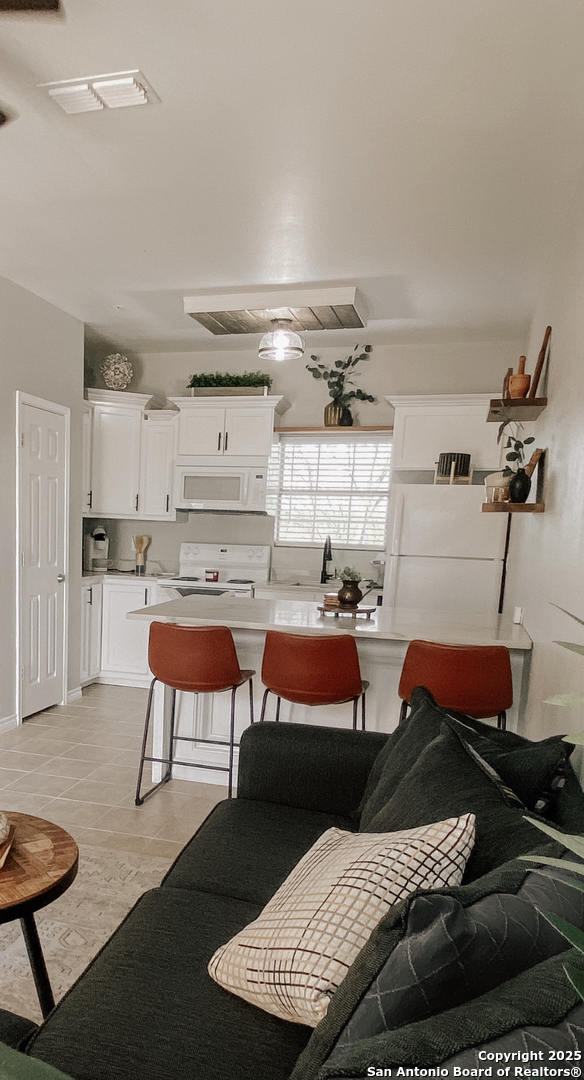 391 Riverside Drive, Unit 21 Eagle Pass, TX 78852 - Photo 8 of 11 a bedroom with a bed and a chair