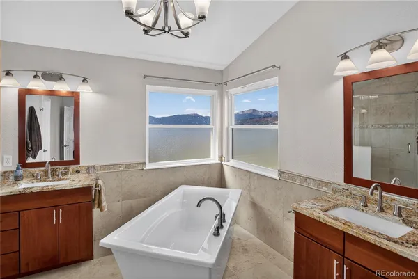 a bathroom with a granite countertop sink a mirror and shower