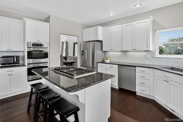 a kitchen with a stove a sink and a refrigerator