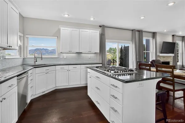 a kitchen with stainless steel appliances granite countertop a dining table and chairs