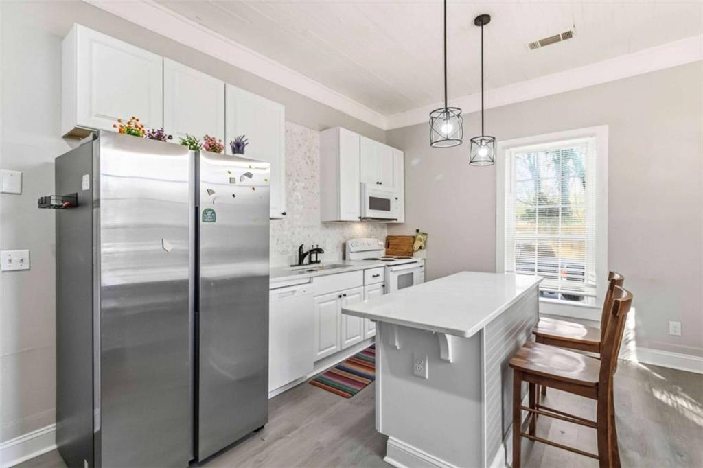 949 East Solomon Street Griffin, GA 30223 - Photo 8 of 26 a kitchen with stainless steel appliances a refrigerator a sink a stove a table and chairs
