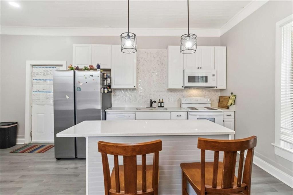 949 East Solomon Street Griffin, GA 30223 - Photo 10 of 26 a kitchen with stainless steel appliances granite countertop a refrigerator a sink dishwasher a stove and white cabinets with wooden floor