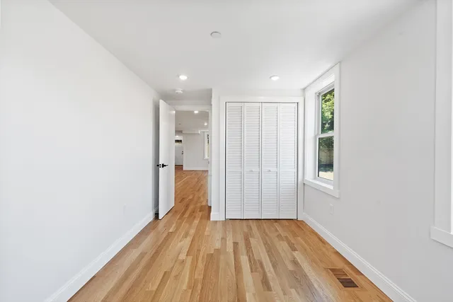 a view of hallway with a large window and wooden floor