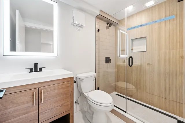 a bathroom with a sink a toilet and shower