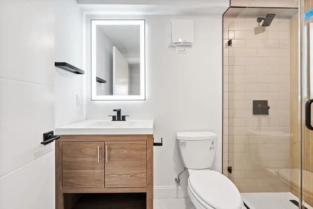 a bathroom with a sink a toilet and shower