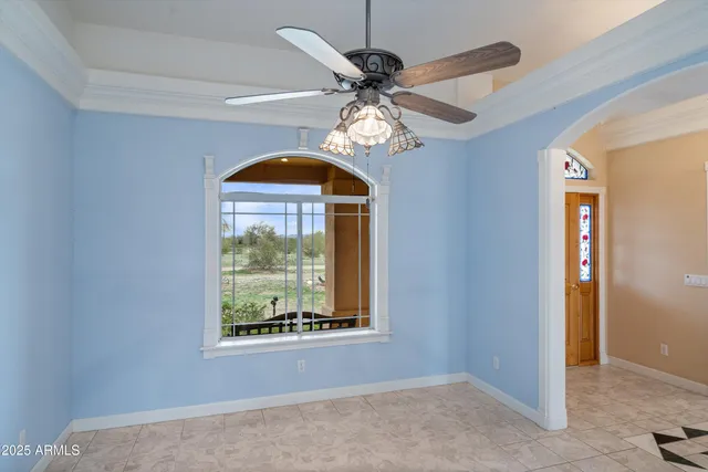 a view of a livingroom with a fireplace a chandelier and windows
