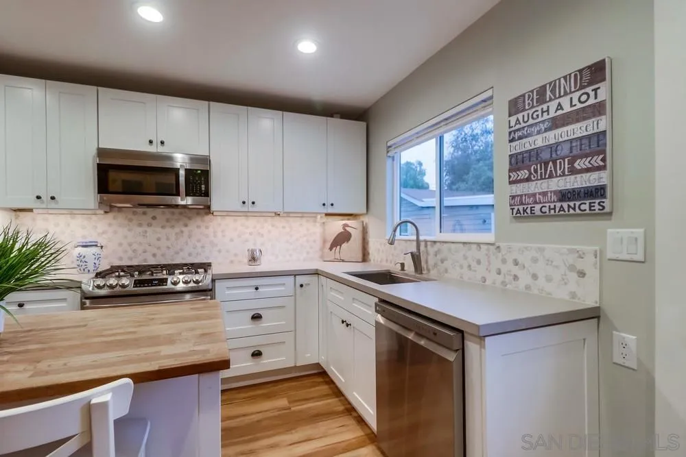 11461 Posthill Place Lakeside, CA 92040 - Photo 16 of 46 a kitchen with stainless steel appliances a stove sink microwave and cabinets